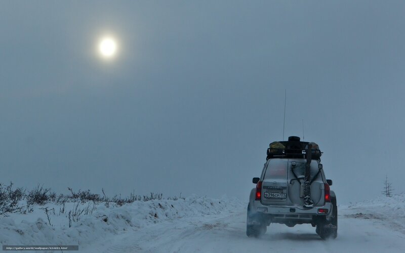 SUV on snowy road at night