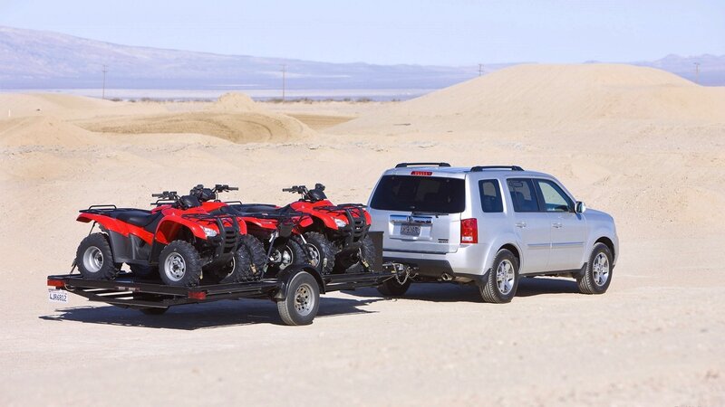 SUV towing ATVs in desert