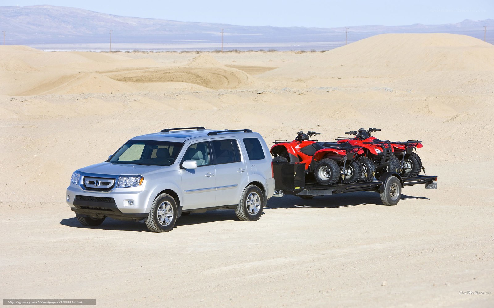 SUV towing ATVs in desert