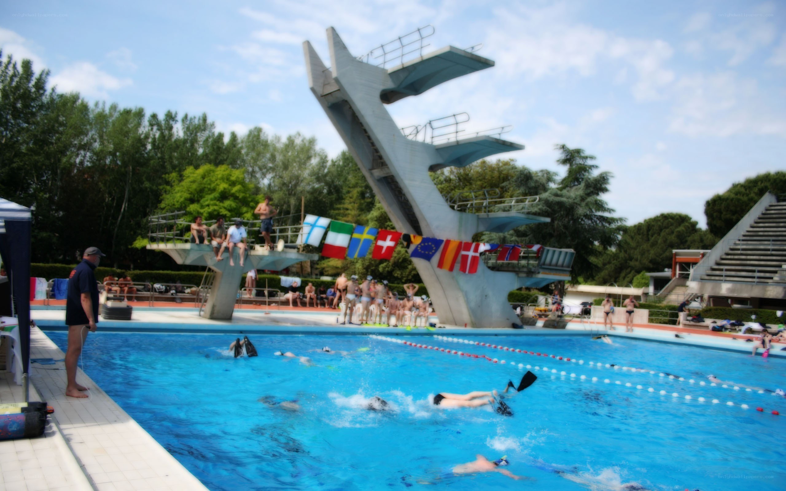 Swimmers at a pool with diving boards