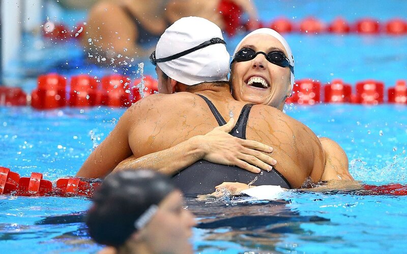Swimmers hugging in pool