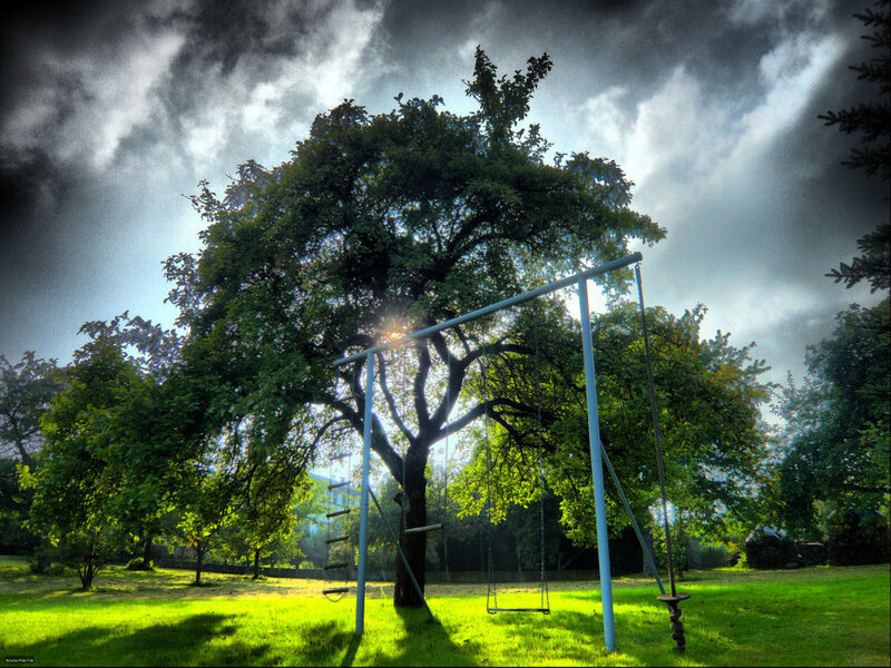Swing set under stormy sky