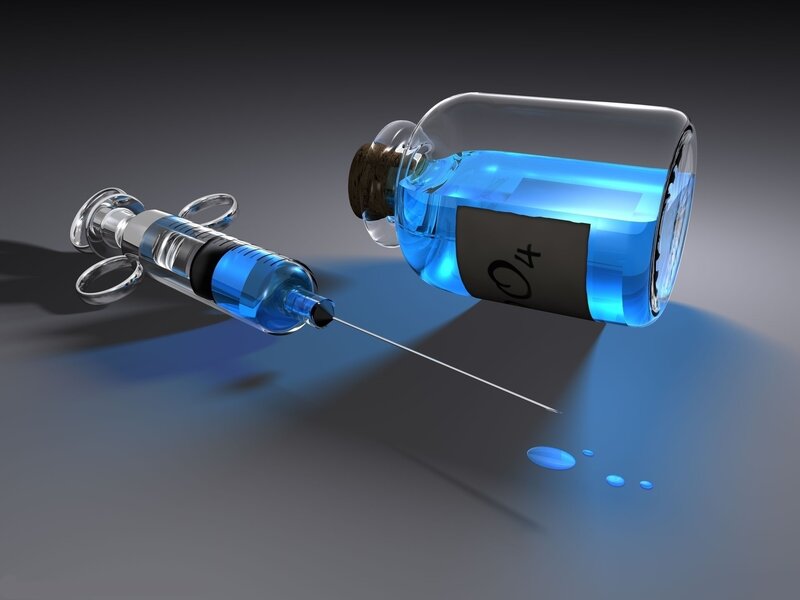 Syringe drawing blue liquid
