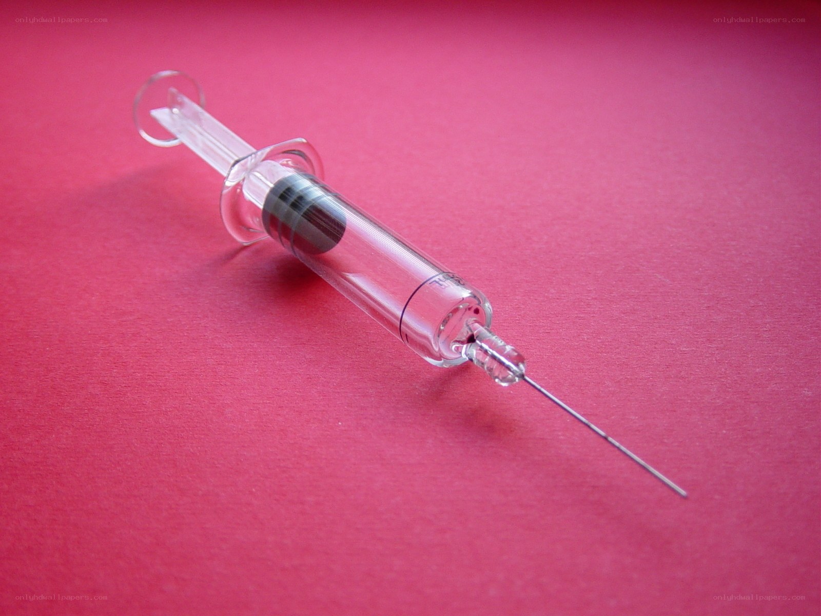 syringe on red surface