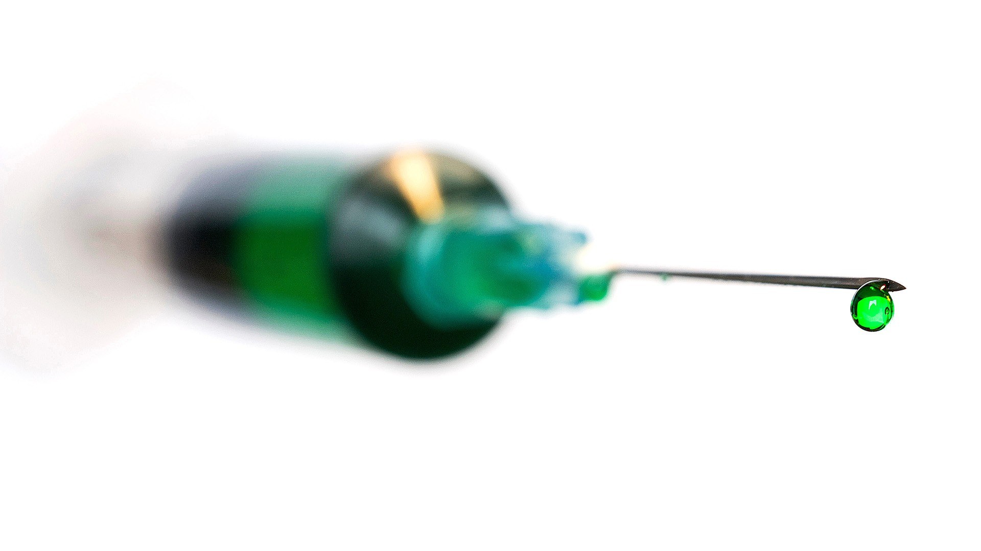 syringe with green liquid drop