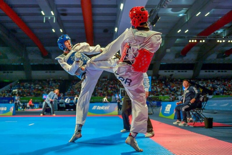Taekwondo Athletes in Action — Blue, Intense, Photograph, Audience, Referee, Mats