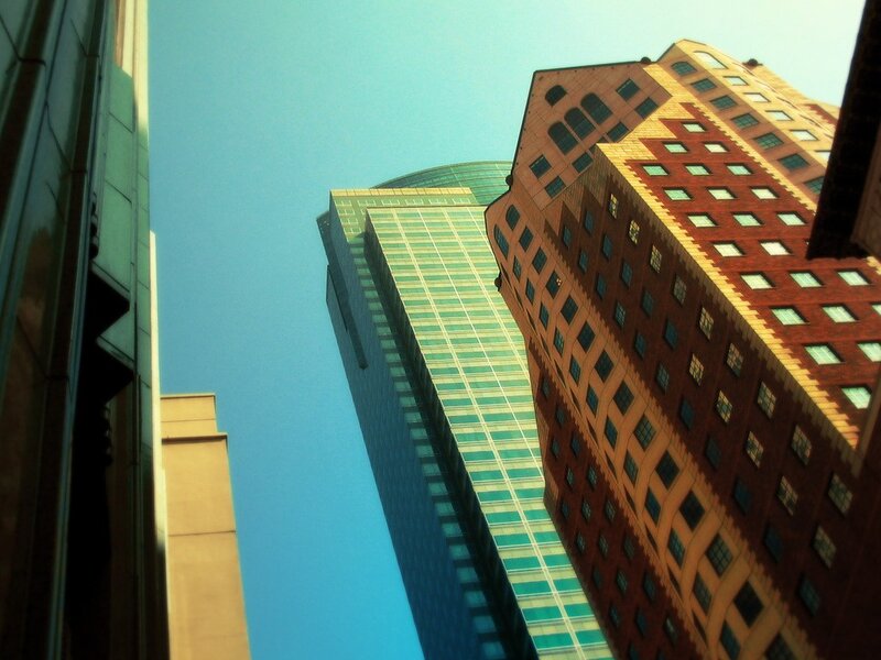 Tall Buildings in City — Blue, Dramatic, Afternoon, Photograph, Skyscrapers, Blue Sky, Brick Facade, Brown