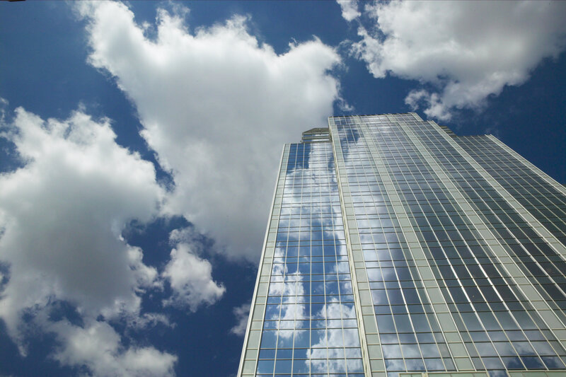 tall glass building under cloudy sky