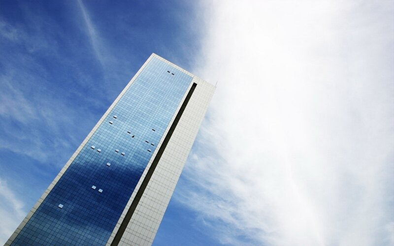 tall glass skyscraper against blue sky