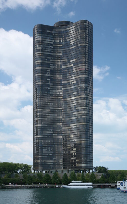 tall glass skyscraper by water