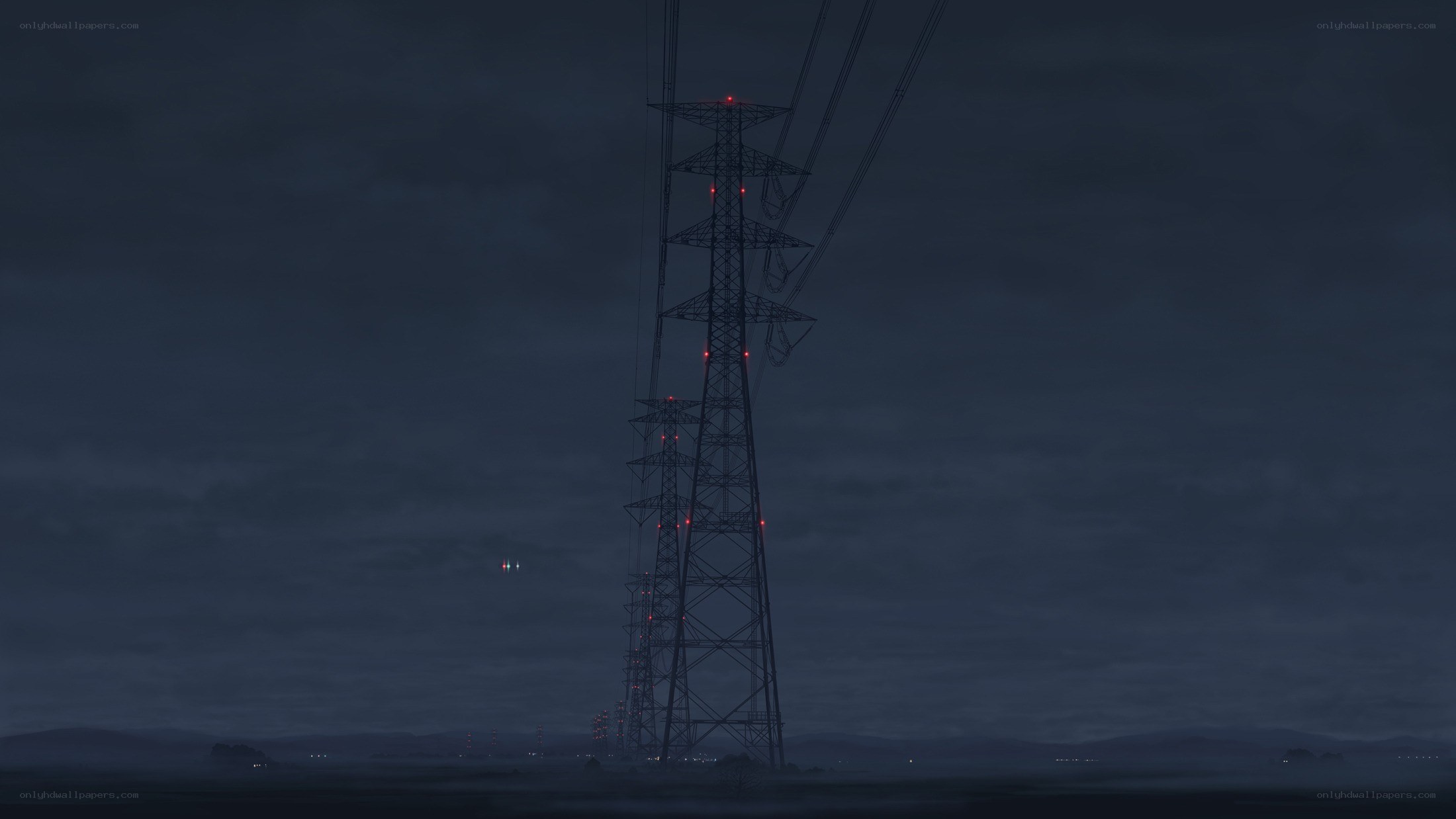 tall power line tower at night