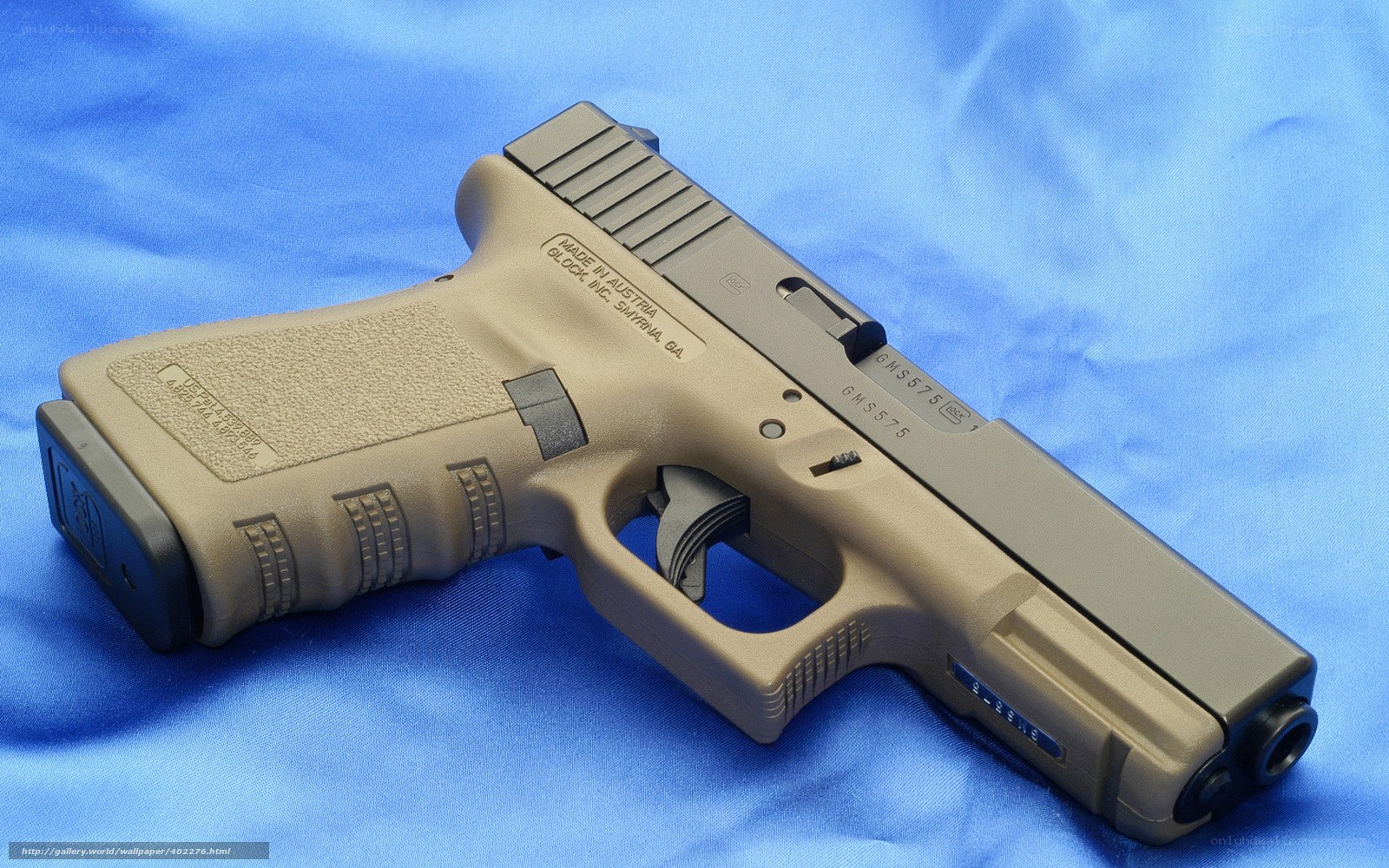 tan-colored handgun on blue cloth