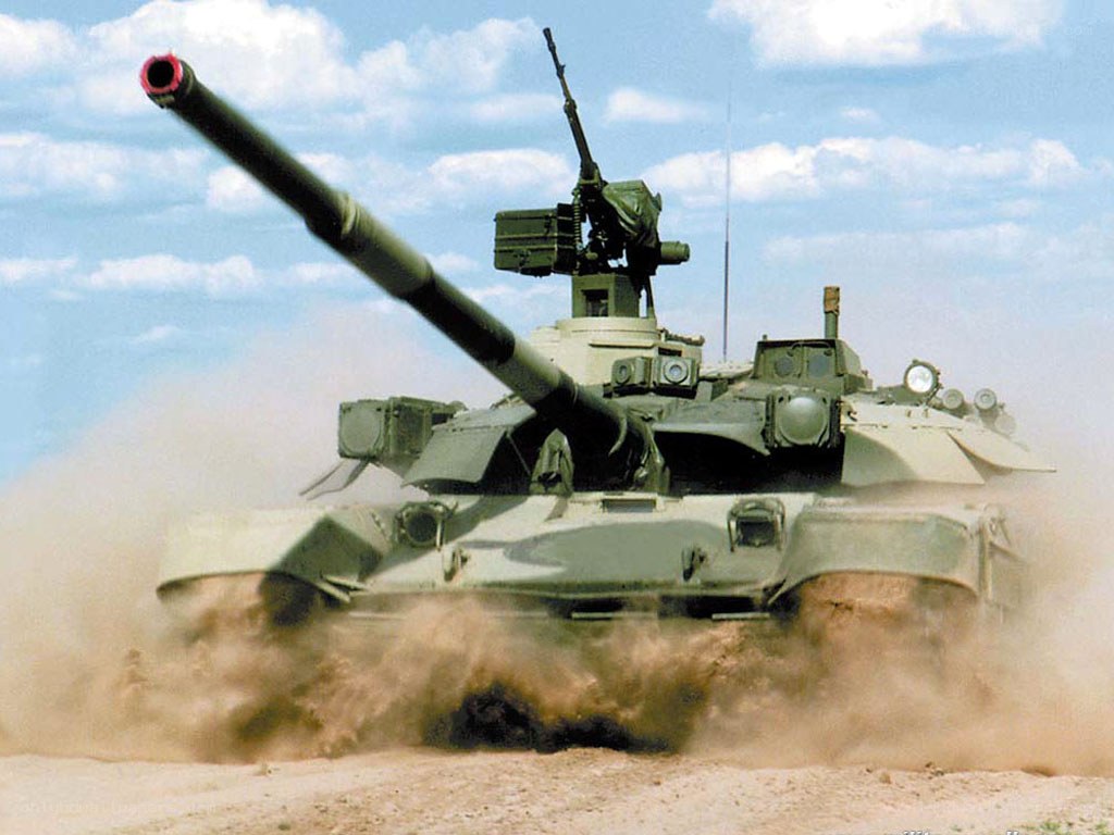 Tank in motion on dusty terrain