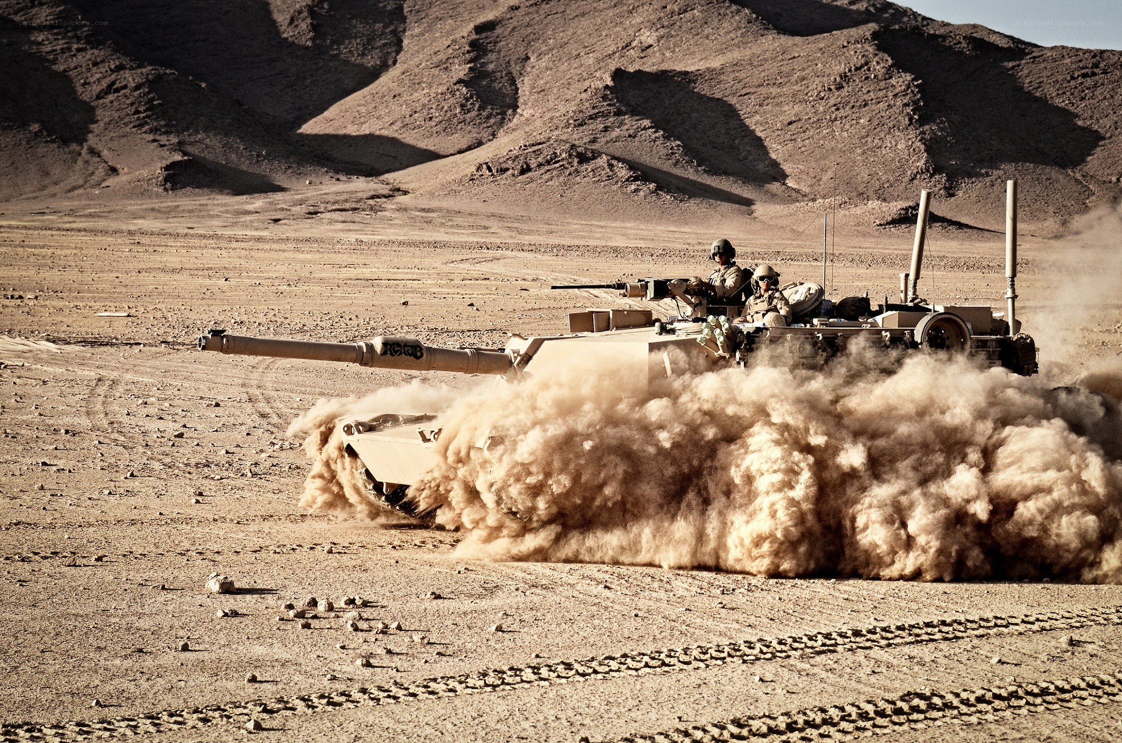 Tank moving in desert terrain