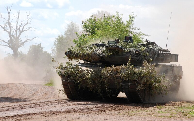 Tank on dirt road with camouflage