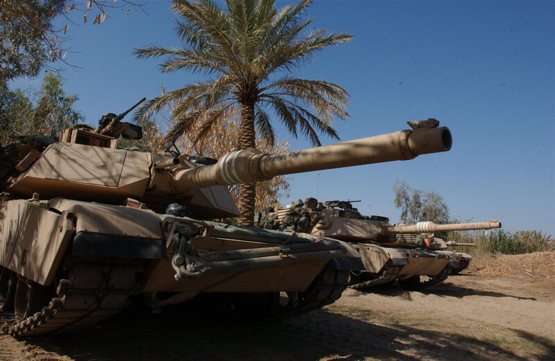 Tanks in desert with palm tree