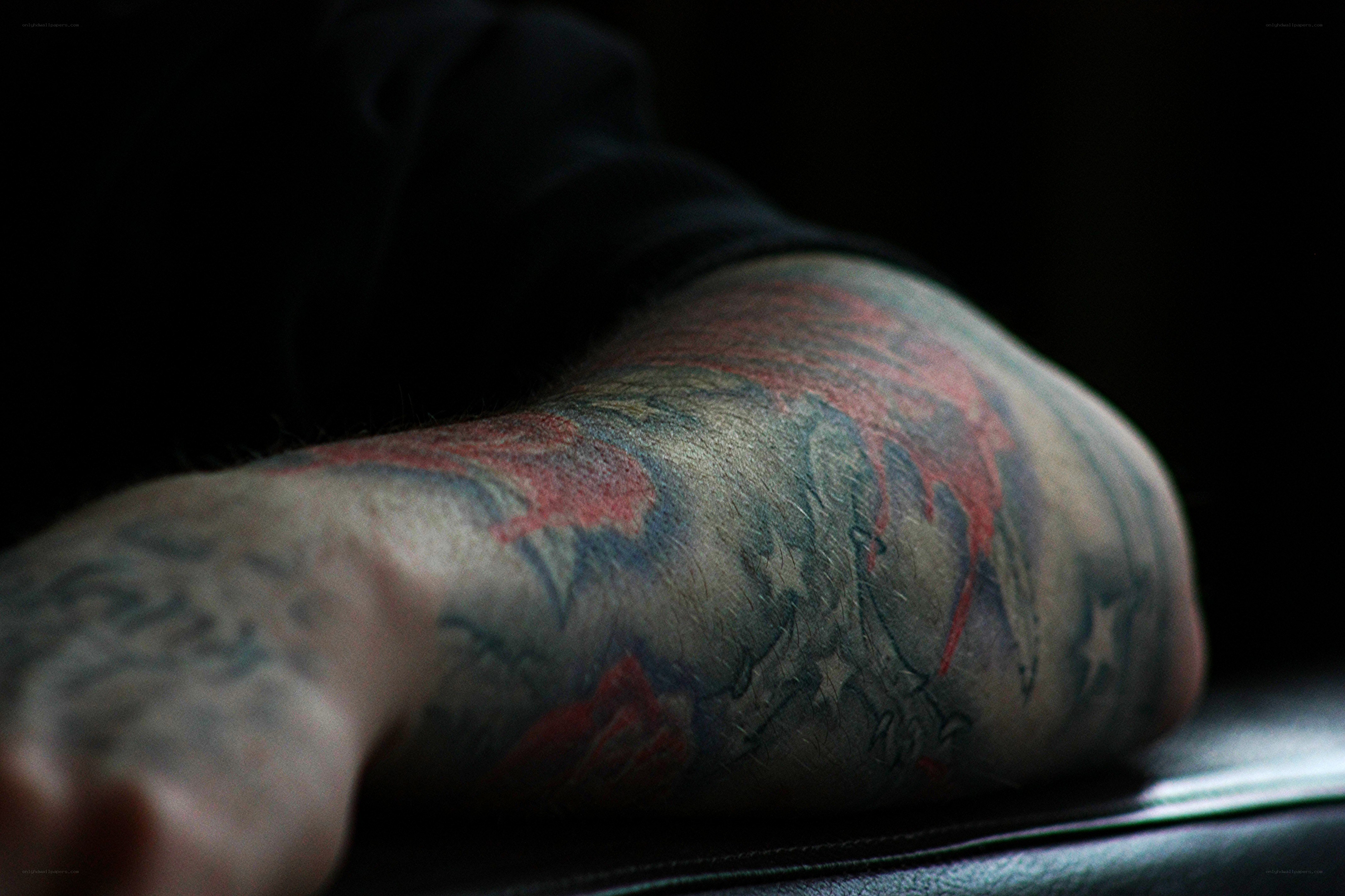 tattooed arm in dim light