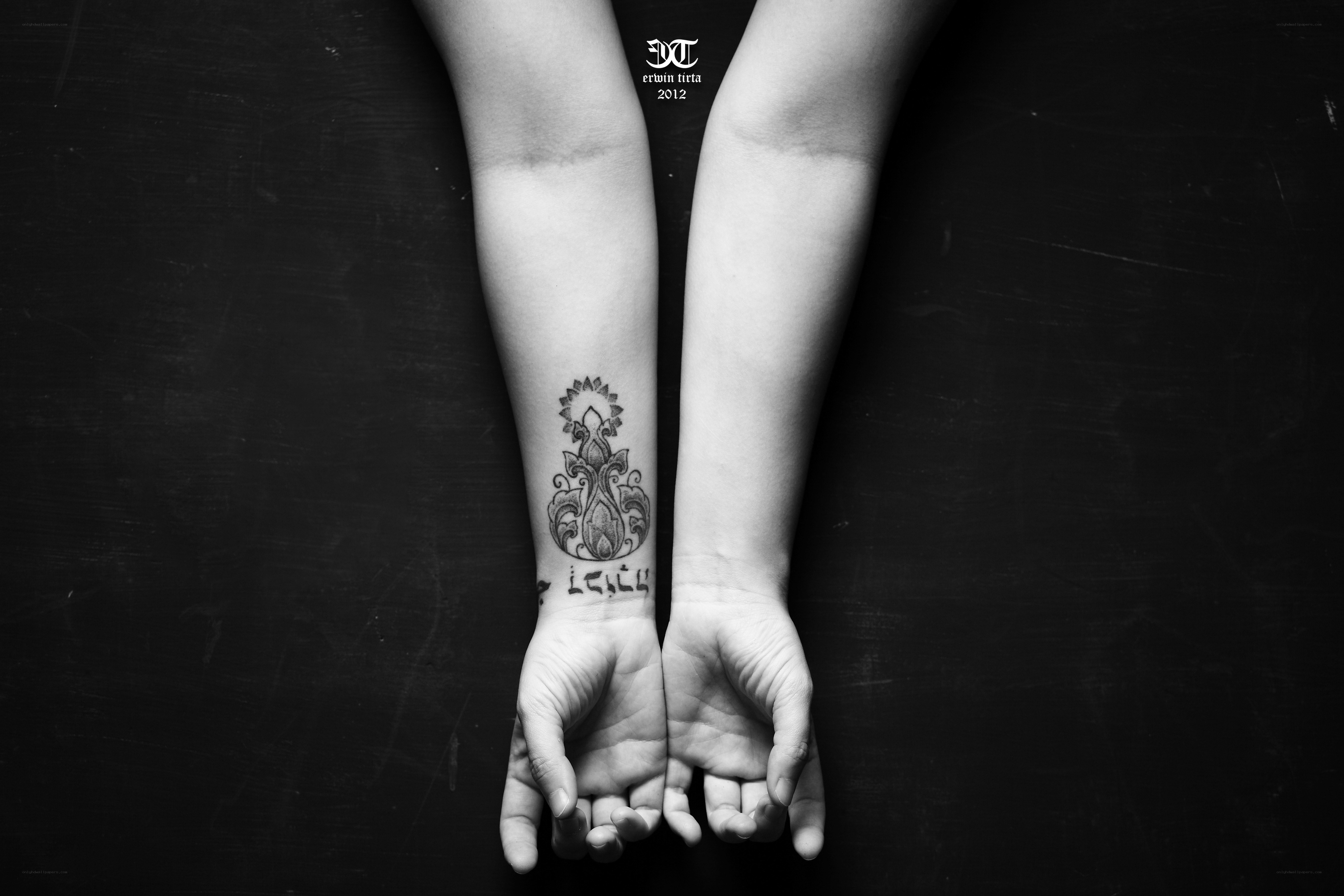 tattooed arms on black background