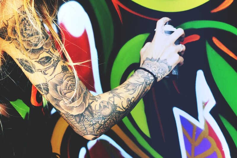 tattooed artist spray painting