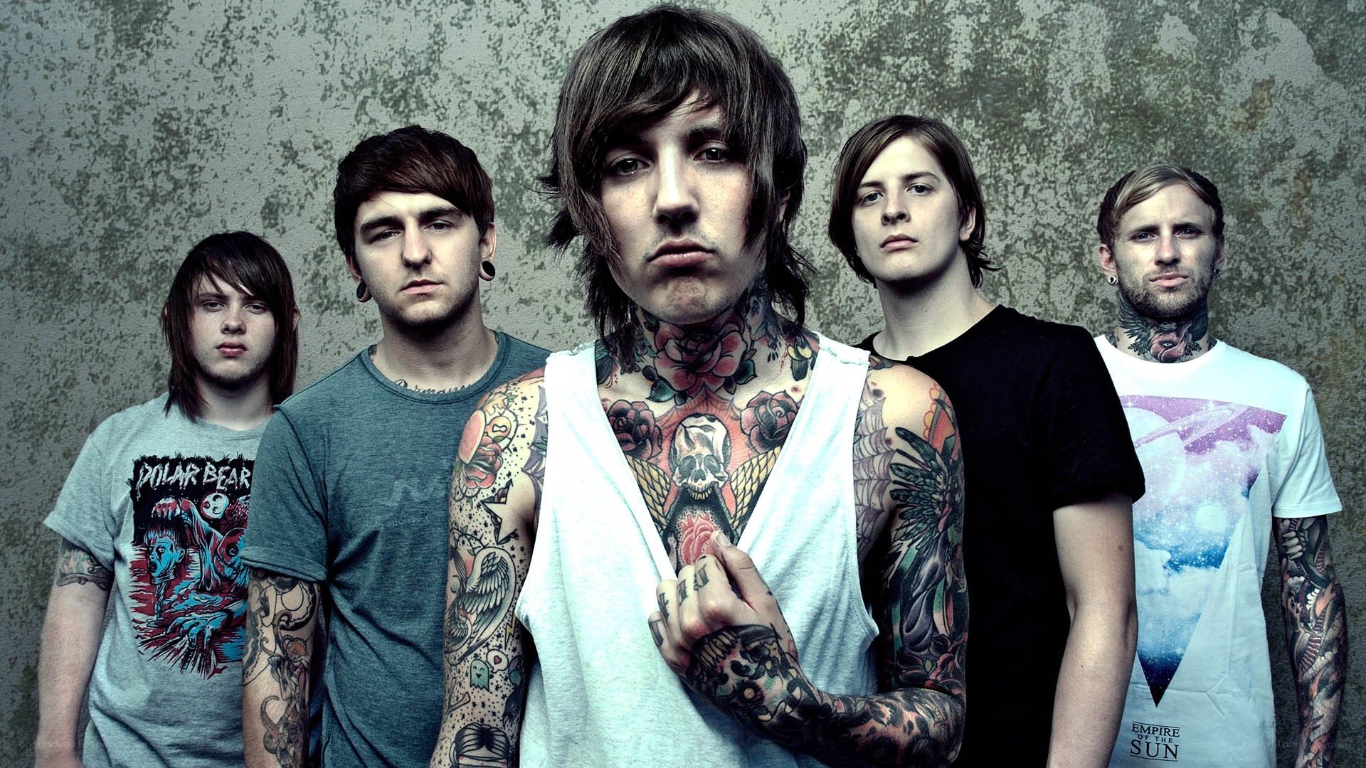 tattooed band members pose together