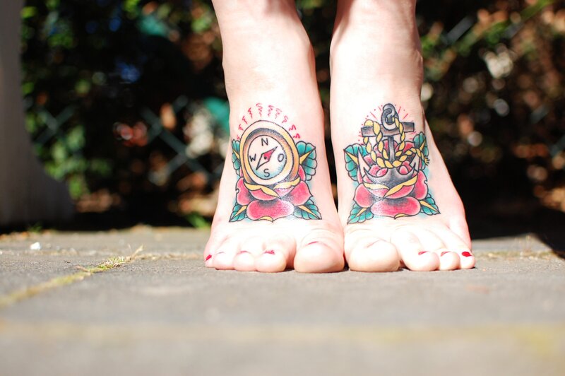 tattooed feet with compass and anchor