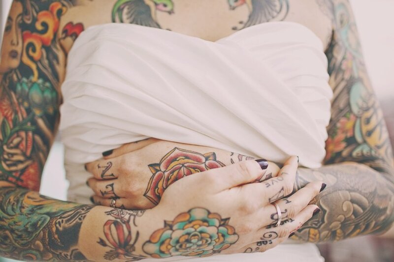 tattooed hands holding fabric