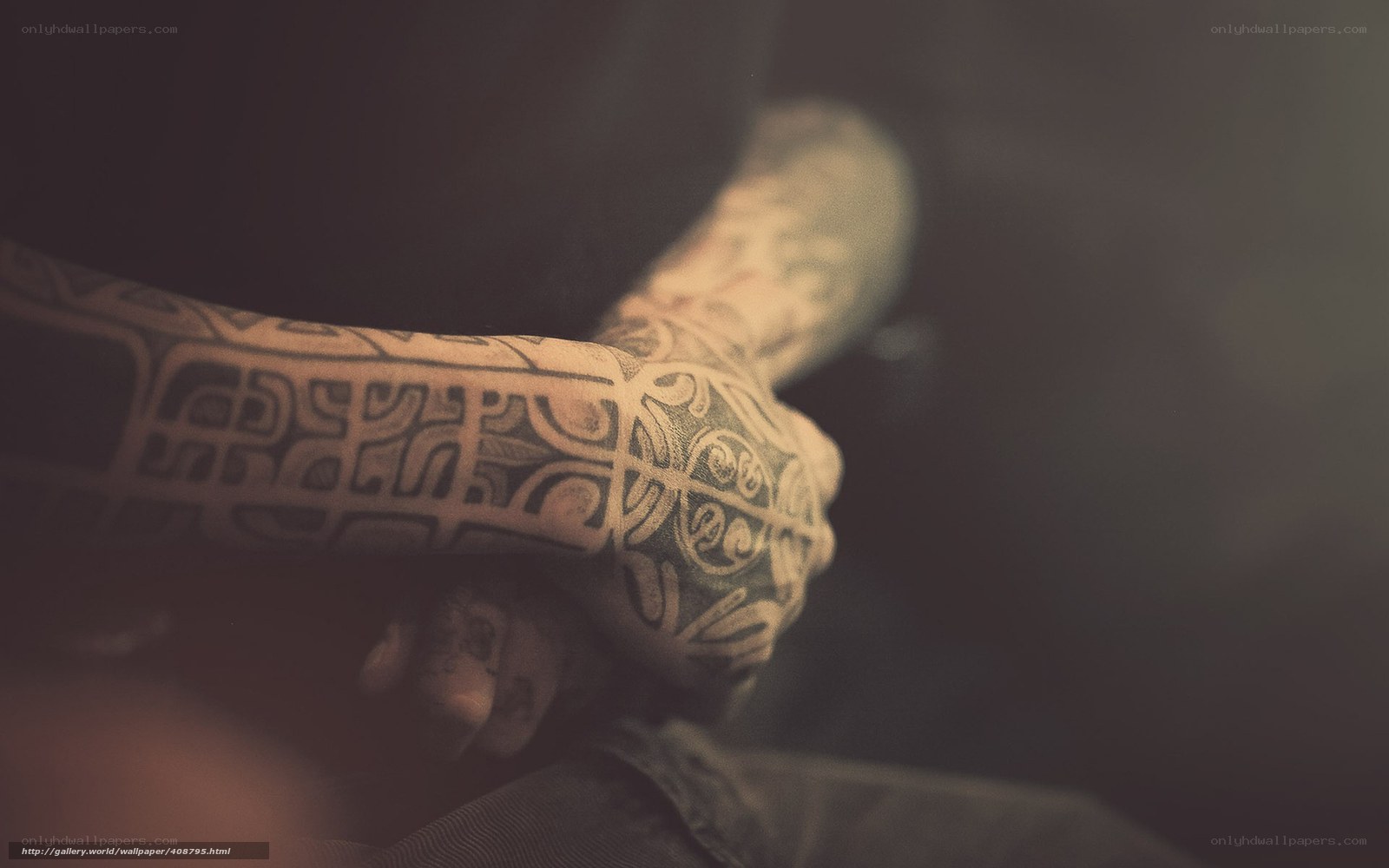 tattooed hands in shadow
