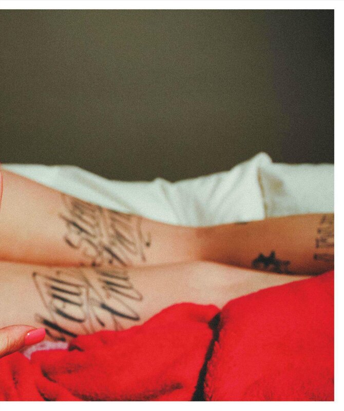 tattooed legs on red blanket