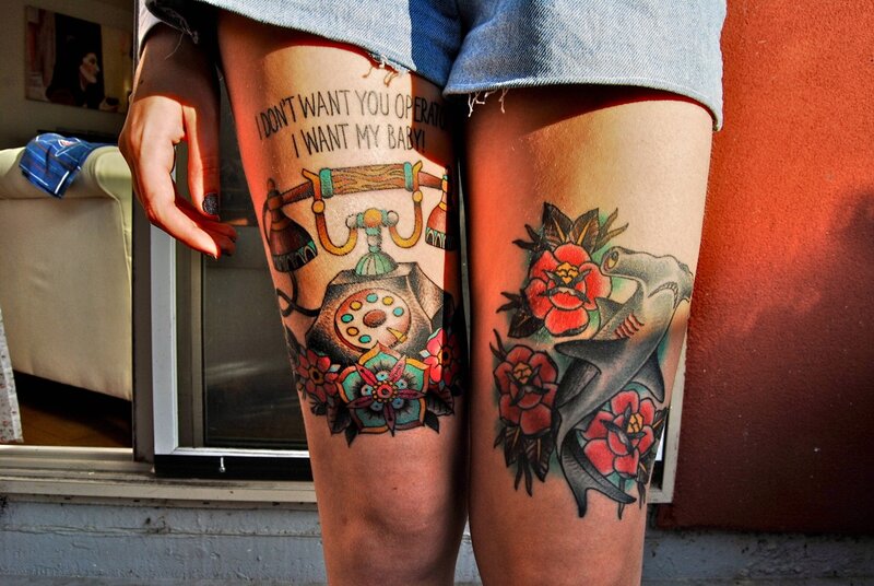 tattooed legs with phone and shark