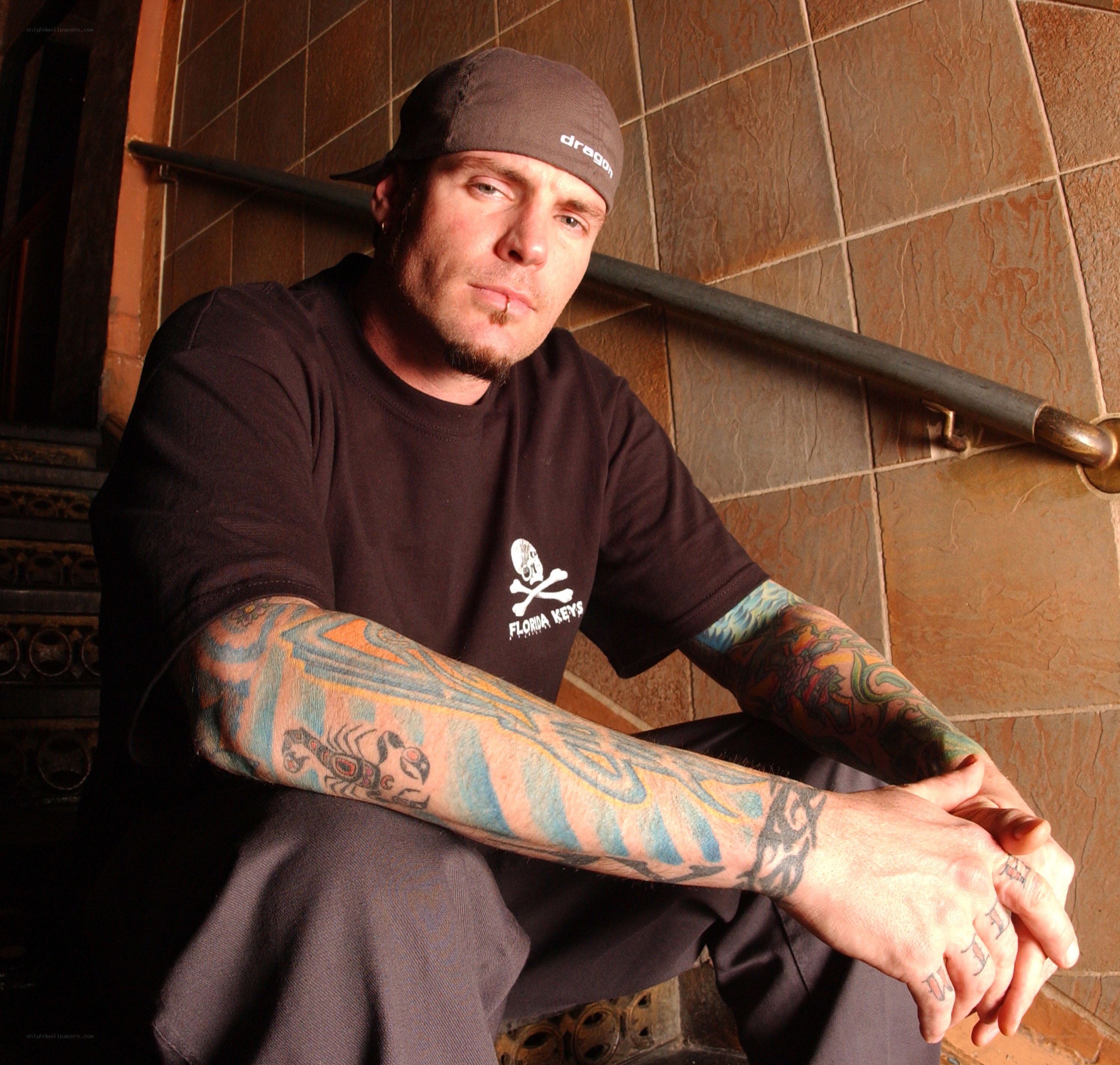 tattooed man in cap