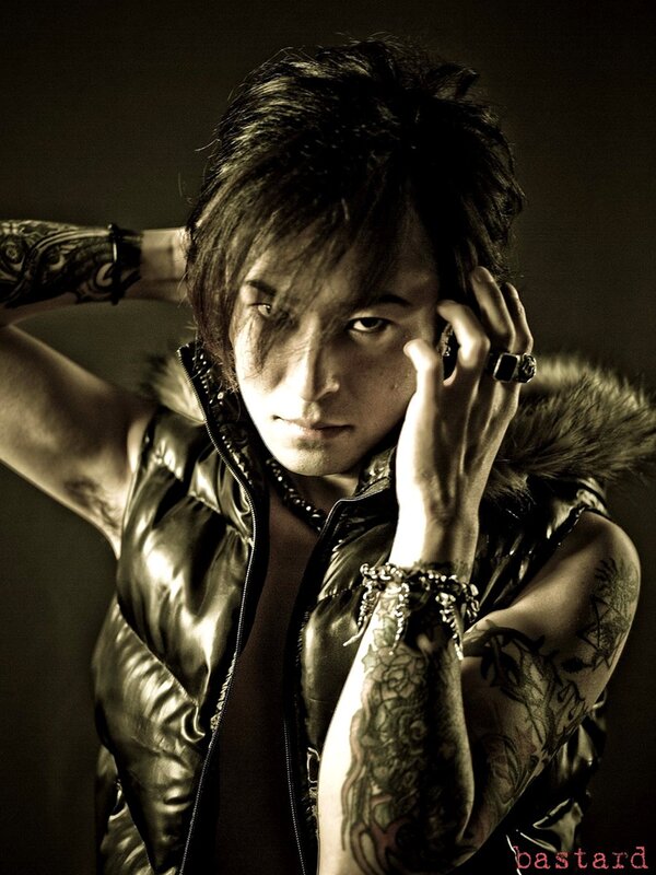 tattooed man in leather vest
