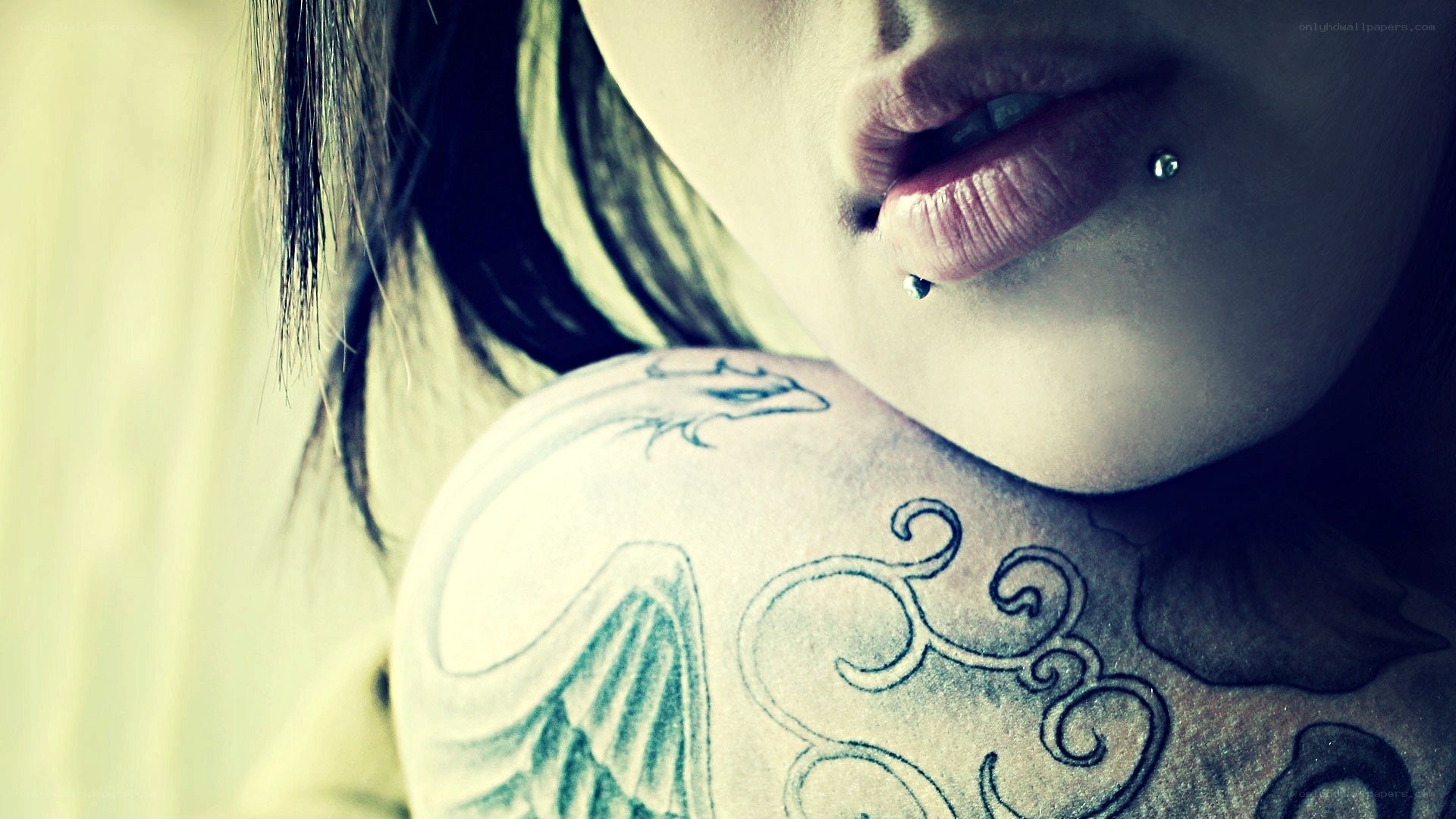 tattooed shoulder and lip piercing