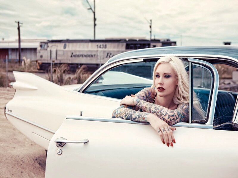 tattooed woman in classic car