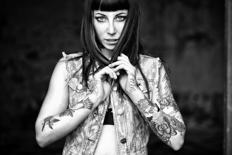 tattooed woman in denim vest