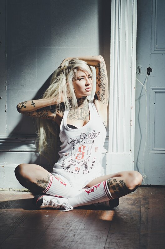 tattooed woman in white tank