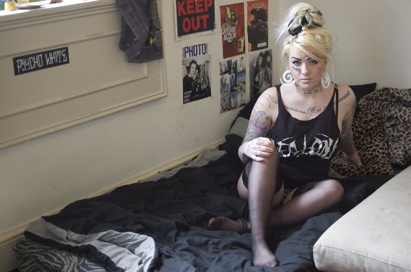 tattooed woman on bed