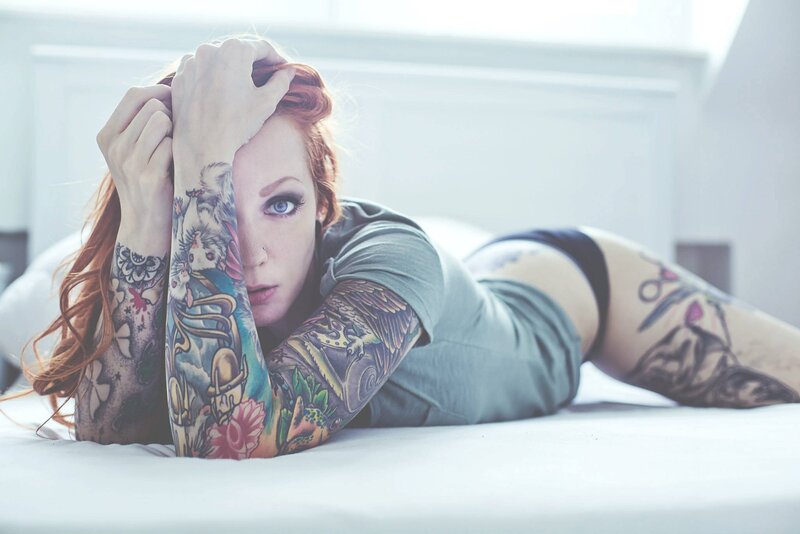 tattooed woman on bed