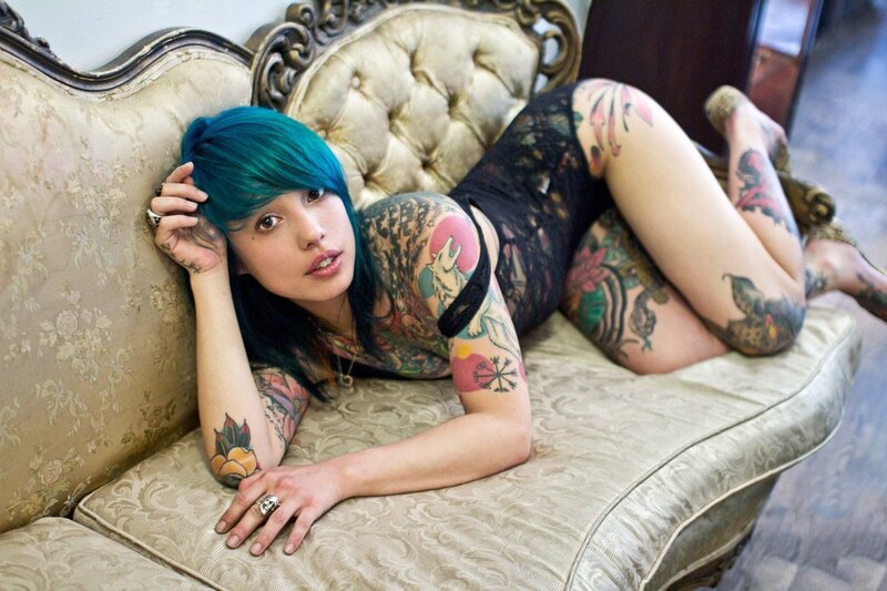 tattooed woman on vintage couch