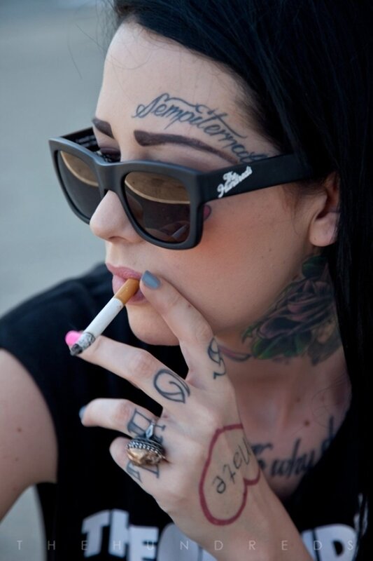 tattooed woman smoking cigarette