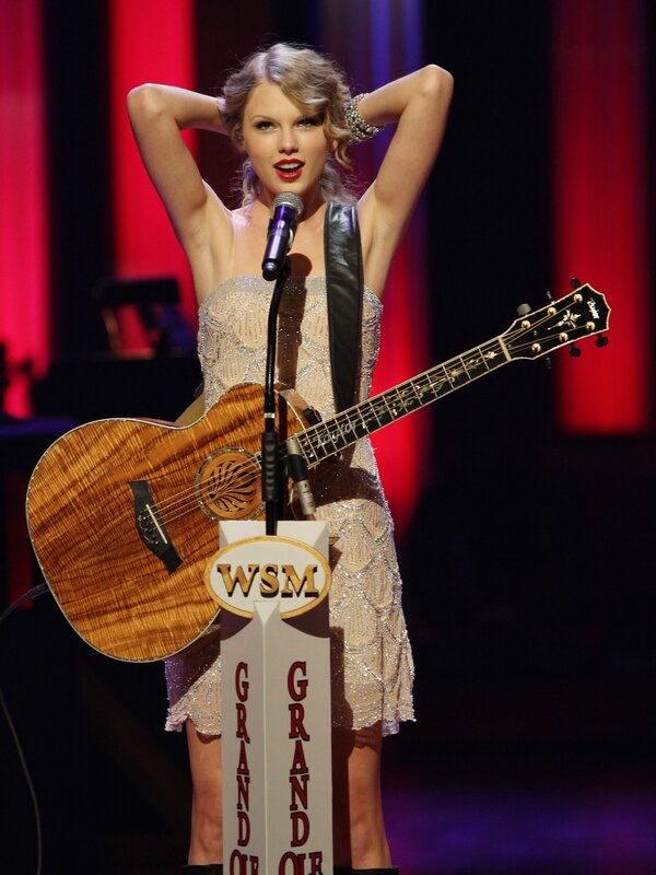 Taylor Swift on stage with guitar