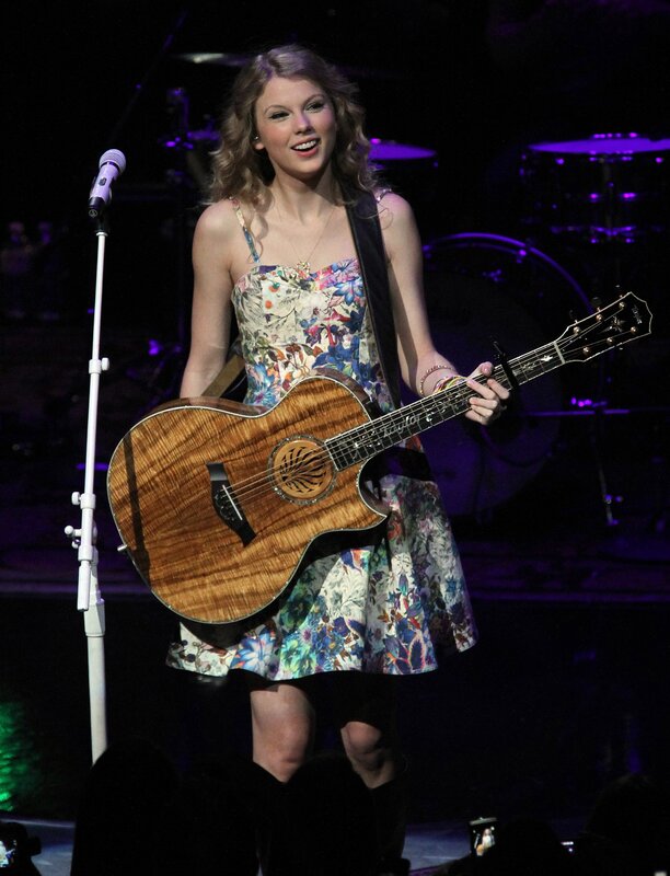 Taylor Swift on stage with guitar