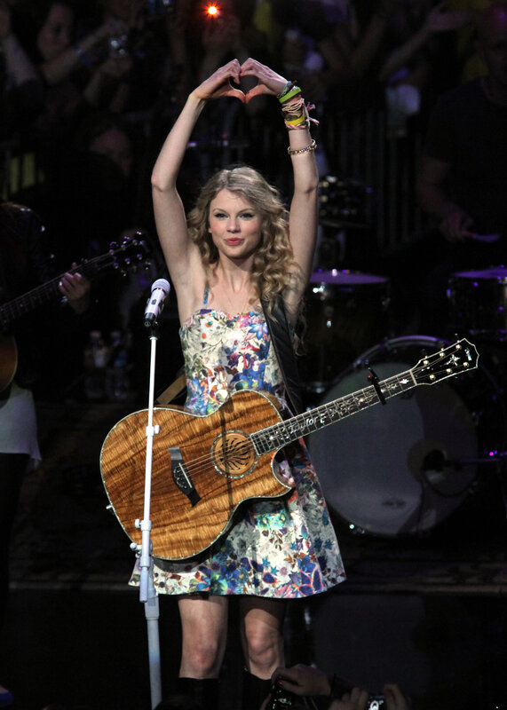 Taylor Swift on stage with guitar