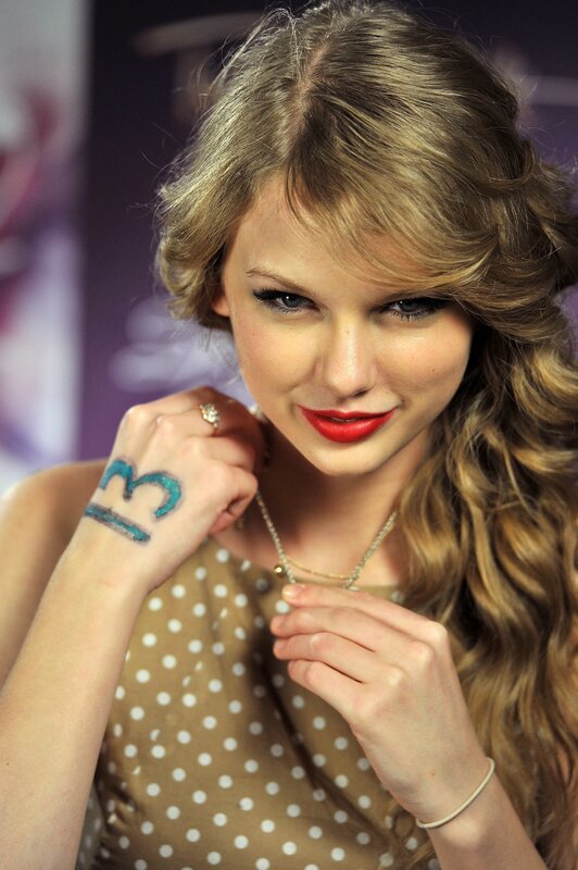 Taylor Swift with number 13 on hand