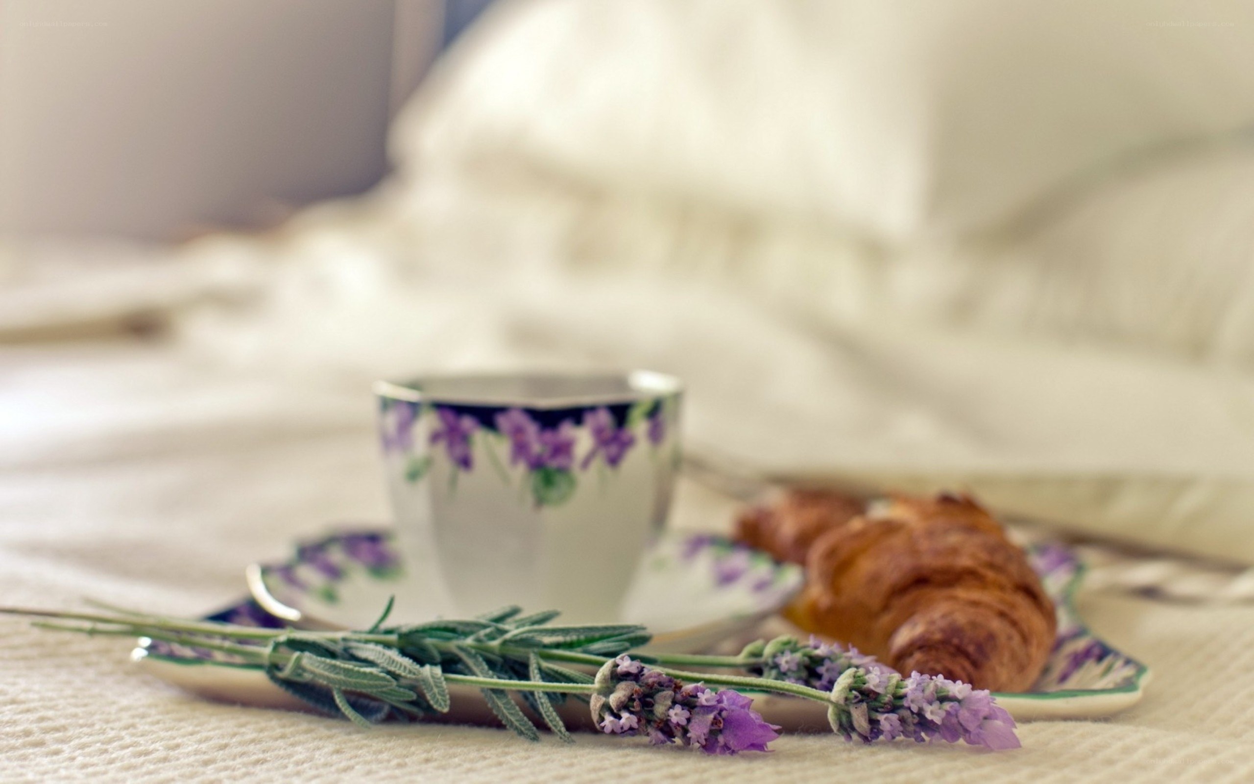 Tea and croissant on bed