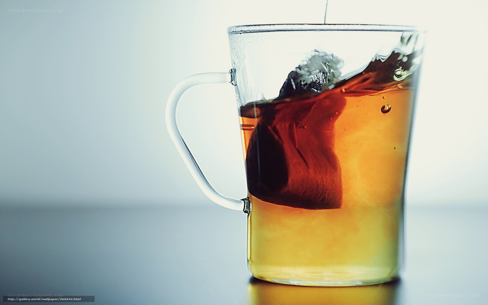 Tea being poured into a glass mug