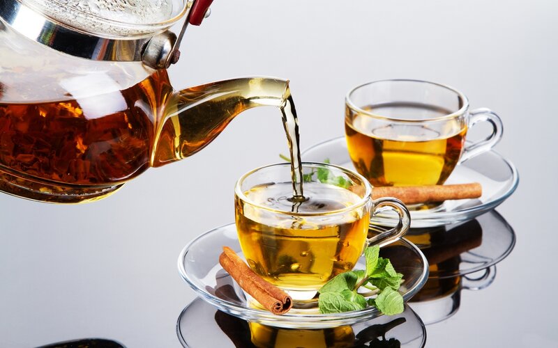 Tea Being Poured into Cup — Gold