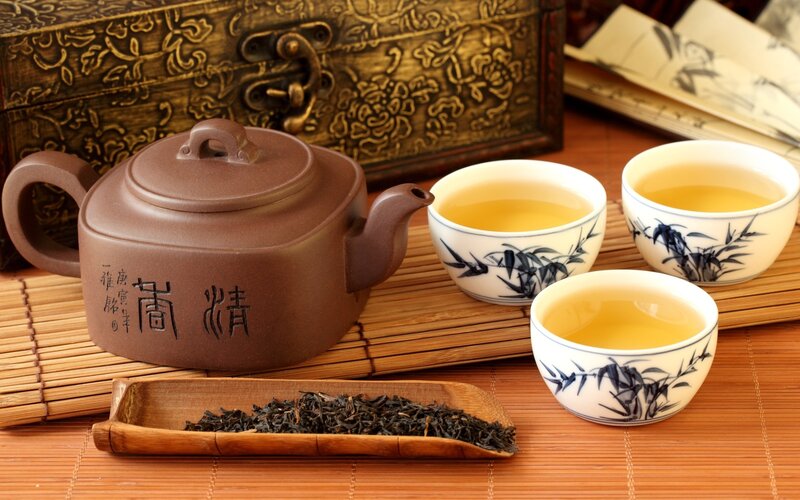 Tea Set on Bamboo Mat — Brown, Serene, Photograph, Teapot, Cups, Tea Leaves, White