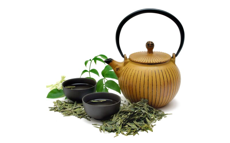 Tea set with green tea leaves