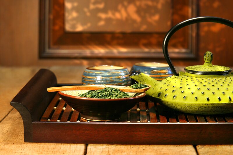 Tea set with green tea leaves