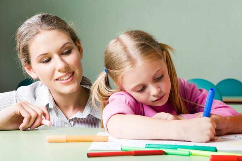 teacher helping student draw